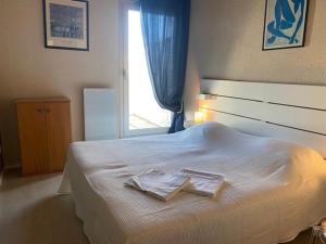 ein Schlafzimmer mit einem Bett mit zwei Handtüchern darauf in der Unterkunft Duplex pour 6 avec vue océan, balcon et garage privatif - FR-1-494-131 in Royan