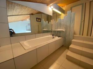 ein Badezimmer mit Badewanne, Waschbecken und Spiegel in der Unterkunft Duplex pour 6 avec vue océan, balcon et garage privatif - FR-1-494-131 in Royan + 7 Fotos