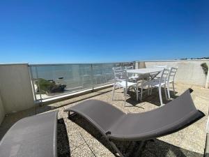 ein Balkon mit Tisch und Stühlen und Blick auf das Meer in der Unterkunft Duplex pour 6 avec vue océan, balcon et garage privatif - FR-1-494-131 in Royan