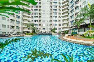 a swimming pool in front of a large apartment building at PECAN by Kozystay - Sudirman in Jakarta