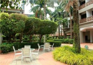 a group of chairs and tables in a courtyard at Frangipani Mahkota Apartment Melaka in Melaka