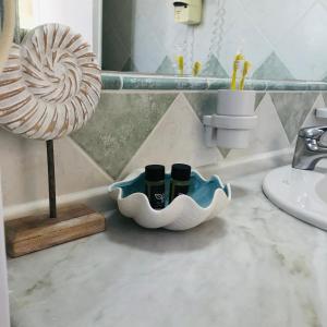 a bathroom counter with three bottles in a holder next to a sink at Leremo Luxury Messonete in Roda +51 photos