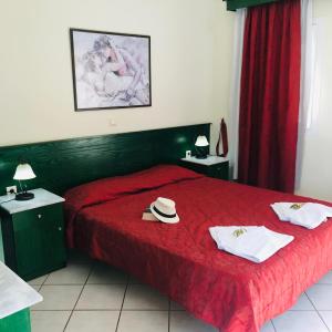 a bedroom with a red bed with a hat and towels at L'eremo Luxury Studio in Roda