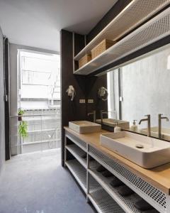 baño con 2 lavabos y espejo grande en On the Bed Hostel, en Bangkok