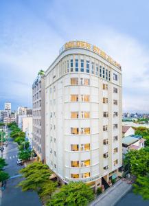 - une vue sur un bâtiment blanc doté d'un panneau dans l'établissement Golden Star Hotel by THG, à Đà Nẵng