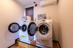 佐賀市にあるHOTEL R9 The Yard 江北の洗濯機2台、洗濯機、乾燥機が備わります。