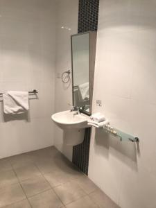 a bathroom with a sink and a mirror at Adara St Kilda in Melbourne