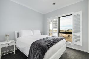 um quarto com uma cama e uma janela com vacas no exterior em The Oxley Estate em Portarlington
