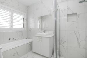a bathroom with a sink, toilet and bathtub at The Oxley Estate in Portarlington