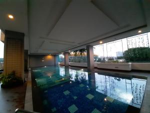 a swimming pool in the middle of a building at Cozy The H Residence Cawang by Bonzela Property in Jakarta