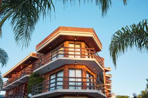 a tall building with windows and a palm tree at Hotel Termas Day in Termas del Daymán