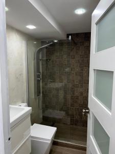 uma casa de banho com um chuveiro, um WC e um lavatório. em Yoa’s escape em San Juan