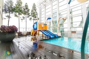 a swimming pool with a slide in a building at Suasana Residence JB City Lifestyle Suites by NEO in Johor Bahru