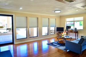 a living room with a couch and a table and windows at Regency Inn & Suites in Gladewater