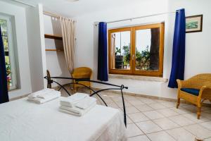 Pokój z łóżkiem, krzesłami i oknem w obiekcie Villa Tina ai Piedi del Faro di Leuca w mieście Leuca