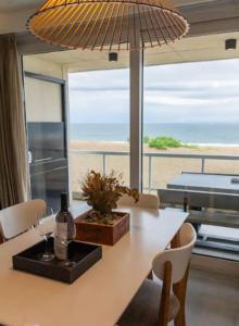 a dining room table with a view of the ocean at Flow Apart & Spa in Las Gaviotas