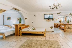 a bedroom with two beds and a tv on the wall at Gazdówka u Janusza in Polańczyk