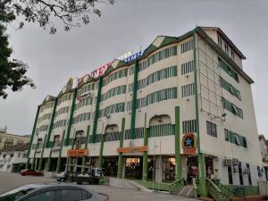 un grand bâtiment blanc avec des finitions vertes dans l'établissement Hotel Super Cowboy, à Malacca