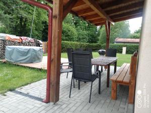 un patio con una mesa y sillas bajo un cenador en Ubytování BRLOH Sedloňov v Orlických horách, en Sedloňov
