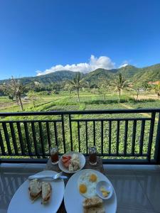 a table with two plates of breakfast food on a balcony at Mesari Homestay & Warung in Amed