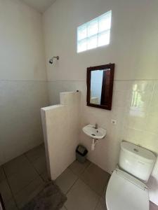 La salle de bains est pourvue de toilettes et d'un lavabo. dans l'établissement Mesari Homestay & Warung, à Amed