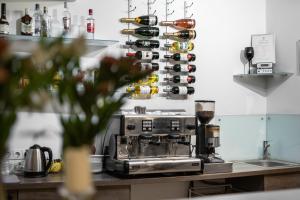 a kitchen with a coffee maker and a rack of wine bottles at Šiaurės Vartai in Joniškis