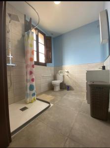 a bathroom with a shower curtain and a toilet at Masia La Bomba in Masnou