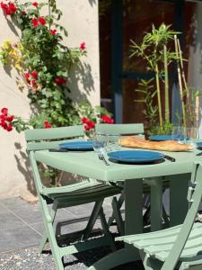 una mesa de picnic con dos sillas y platos. en Appartements cocons dans les Corbières, en Villesèque-des-Corbières