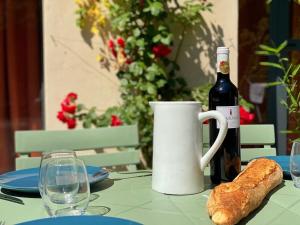 una bottiglia di vino e una pagnotta di pane su un tavolo di Appartements cocons dans les Corbières a Villesèque-des-Corbières