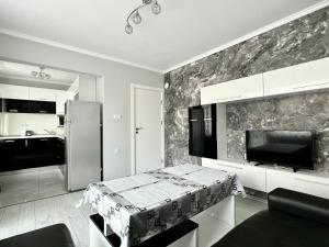 cocina con mesa y nevera en TEA Apartments, en Pomorie