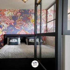 a bedroom with a bed with a floral wallpaper at BB aan de Zuyderzee in Bunschoten