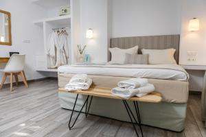 ein Schlafzimmer mit einem Bett und Handtüchern auf dem Tisch in der Unterkunft Korali Boutique Hotel in Naxos Chora