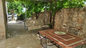 une table en bois avec des chaises et un mur en pierre dans l'établissement Casa Ciccone Cardone, à Locorotondo