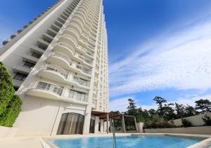 a hotel with a swimming pool next to a building at Kamogawa Grand Tower in Kamogawa