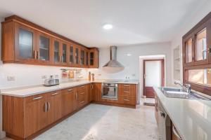 a kitchen with wooden cabinets and a sink at Villa Lumb in Capdepera