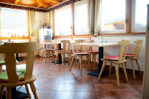 a dining room with tables and chairs and windows at Gästehaus Christa **** in Leibnitz