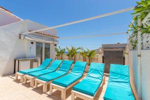 een rij blauwe strandstoelen op een balkon bij Villa with private Heated pool in Casas de Torrat