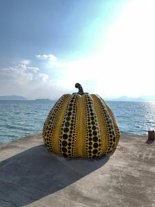 a large yellow object sitting on the side of the water at maison de stuffmarket in Takamatsu