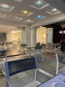 a dining room with tables and chairs and people at Palatino Hotel in Parga