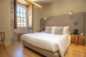 Un dormitorio con una cama blanca grande y una ventana en Quinta da Casa Amarela- Casas da Quinta - Turismo em Espaço Rural, en Lamego