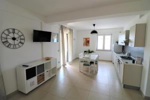 a kitchen and dining room with a table and a clock on the wall at Villa di Marinella in Ascea +36 photos