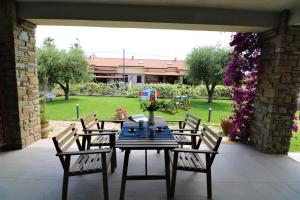 einen Tisch und Stühle auf einer Terrasse mit Garten in der Unterkunft Villa di Marinella in Ascea
