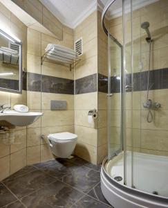 y baño con ducha, aseo y lavamanos. en Hotel Billurcu, en Ayvalık