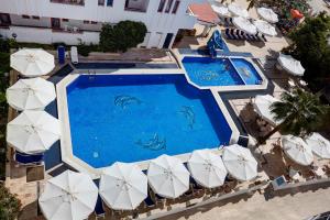 艾瓦勒克的住宿－比爾盧庫酒店，享有带遮阳伞的游泳池的顶部景致