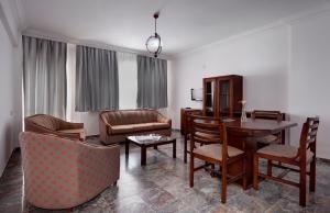 Hotel Billurcu في أيفاليك: غرفة معيشة مع طاولة وكراسي وأريكة