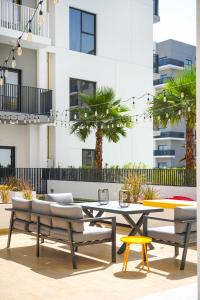 a patio with a table and chairs and palm trees at YouCo coliving Dubai in Dubai