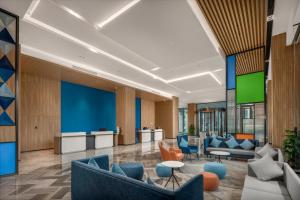 北海市にあるHoliday Inn Express Beihai Silver Beach, an IHG Hotelの青い椅子とテーブルが備わるオフィスロビー