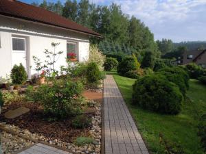 a garden with a brick walkway next to a house at Luxury apartment fireplace + sauna in Stará Paka