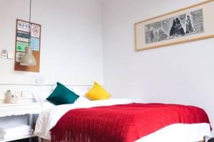 a bedroom with a red and white bed with colorful pillows at Yangshuo Xingping This Old Place Li-River Inn in Yangshuo