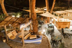 un patio extérieur avec des tables, des chaises et un arbre dans l'établissement Holiday Eolie Village, à Vulcano